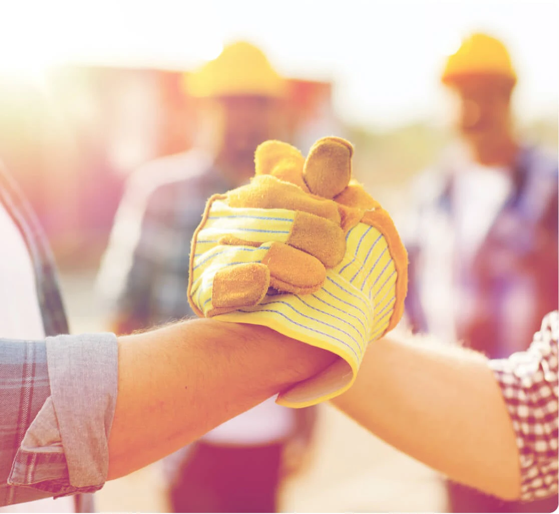 Handschlag mit Handschuhen auf einer Baustelle